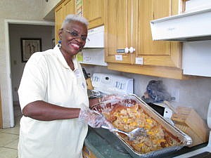 Cynthia Mingo shows off the meal prepared by AME Churches