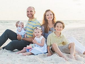 The Boykin Family sits together on a beach