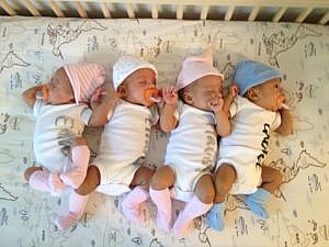 The Mwenda quadruplets snuggle together for the 3 month old photos